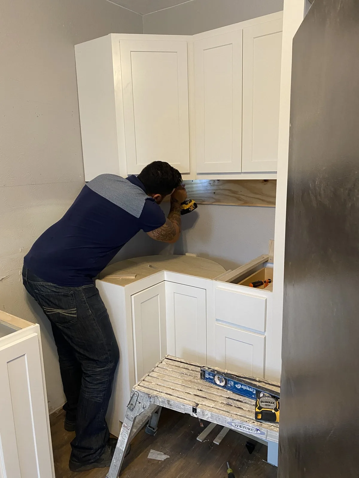Murillo, founder of Dallas Craftworks Co., hand-installing custom cabinetry on a Dallas renovation job site